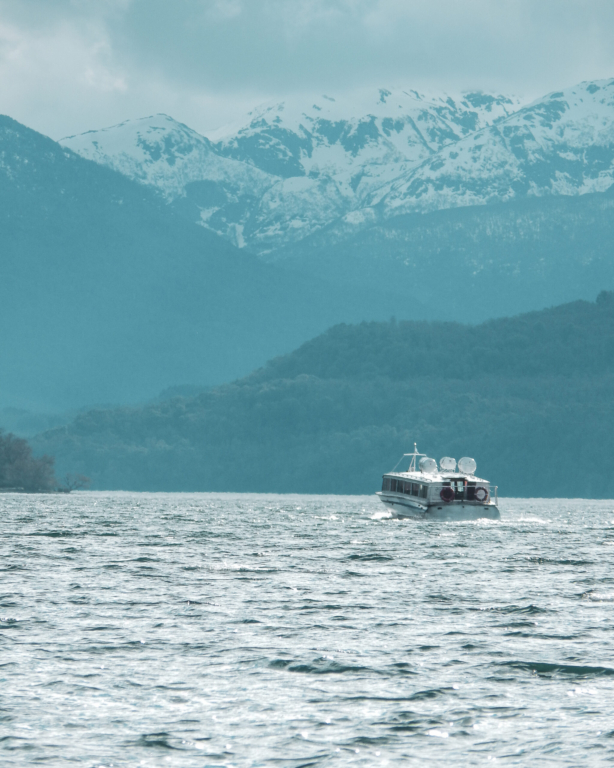 Lancha navegando el Lago Lácar con las montañas de fondo